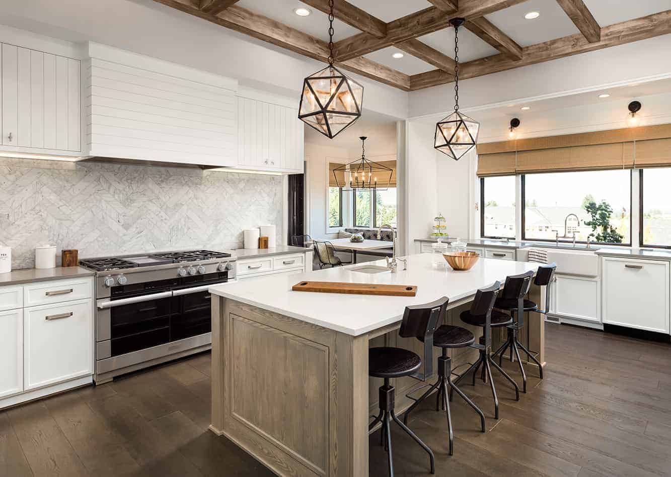 Luxury Kitchen with white cabinets, white counter tops, and a large island with a wood base