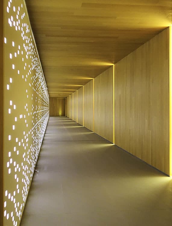 Long Professional Hallway Illuminated by Unique Wall Lights