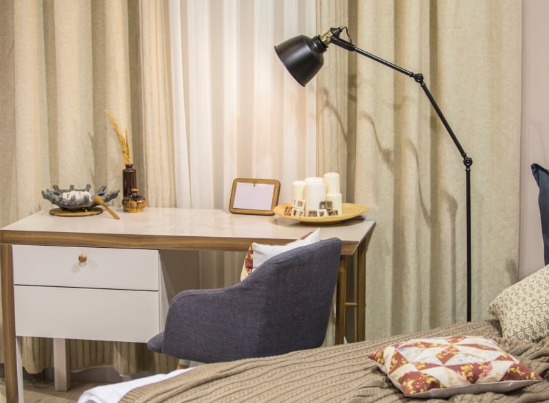 A modern room in the Scandinavian style - a bed, a desk, an armchair, curtains, a contemporary bedroom and workplace decor.