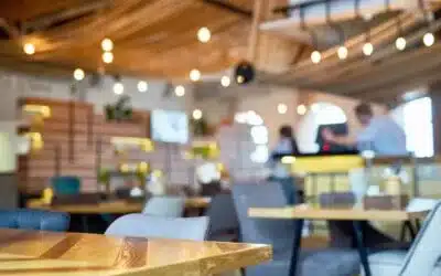 Photo of restaurant from table with other tables, bar counter and employees in background